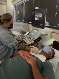 Radiology technician conduct a medical examination of a patient's neck using an ultrasound machine. With precision and expertise, they utilize the technology to capture detailed images, aiding in the diagnosis and treatment of the patient's condition. The technician proficiency ensures accurate and thorough assessment, contributing to optimal healthcare outcomes.