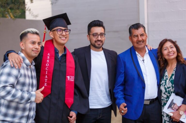 A CBD College graduate celebrates with their family, smiling and posing for a photo together.