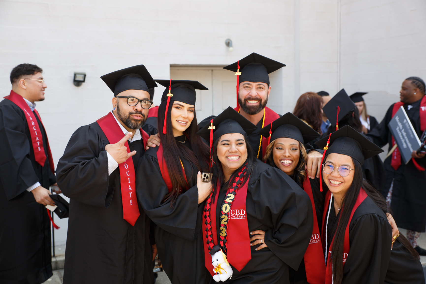 A group of CBD College graduates are smiling happily, radiating joy and satisfaction as they celebrate their achievements together. Their smiles reflect the pride and camaraderie shared among them, marking the culmination of their educational journey and the beginning of new opportunities in their respective careers.