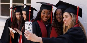 A group of female graduates from CBD College celebrating their graduation ceremony, wearing graduation robe and caps.