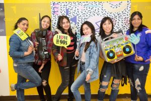 Students gather around a vintage arcade game, embracing the 90s nostalgia at CBD College's Student Appreciation Day.