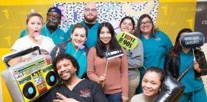 Students at CBD College gather around a photo booth adorned with 90s props to capture memories of the special day.