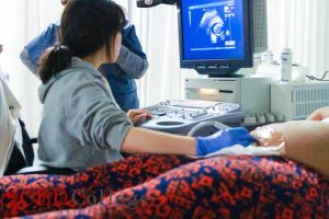 Female doctor performing an ultrasound scan on a pregnant woman.