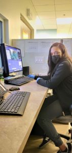 Portrait of Marie Barrett, student in the MRI Program at CBD College, with a computer.