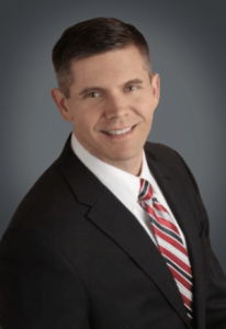 Portrait of John Childs, founder and CEO of Evidence in Motion and partner in Confluent Health, based in Texas, USA. John is a distinguished figure in the physical therapy field, recognized as a 'Health Care Hero' and the youngest ever Fellow of the American Physical Therapy Association.