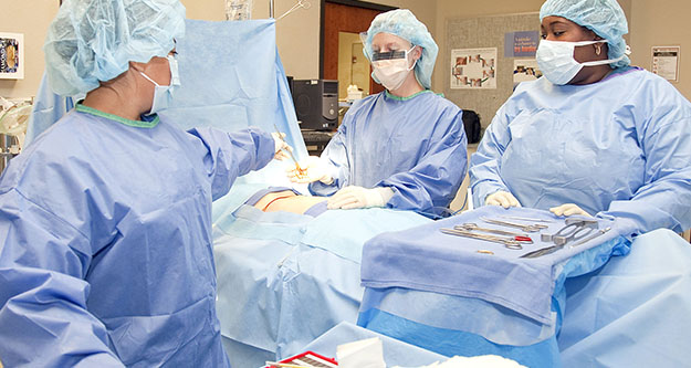 Three surgical technicians in an operating room.