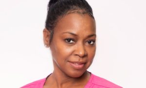 A Female medical assistant wearing a pink blouse.