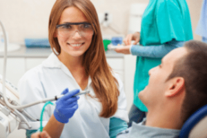Image of a dental doctor examining a patient's teeth during a dental check-up, with the patient seated in a dental chair and the dentist using dental tools to perform the examination.