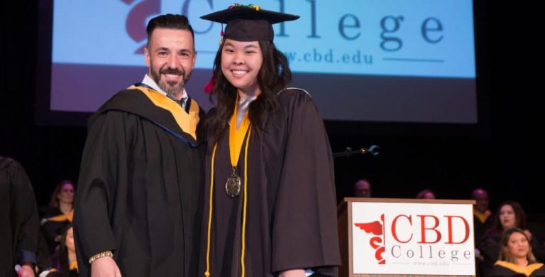 Close-up photo of Crystal Lee, RDMS, smiling with joy as she receives her certificate during the graduation ceremony.