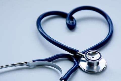 Close-up of a stethoscope, one black, resting on a white surface, representing medical equipment used by doctors for auscultation and diagnosis.