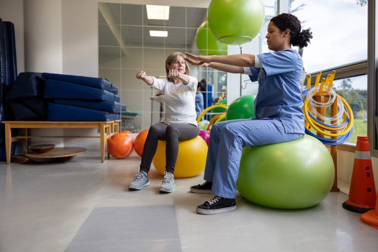 An occupational therapist assistant working with a patient, providing assistance and support during therapy sessions or activities.