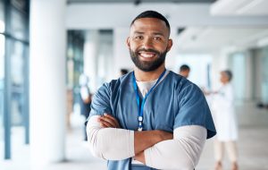 mri technician standing in hospital hallway smiling at camera with hands crossed